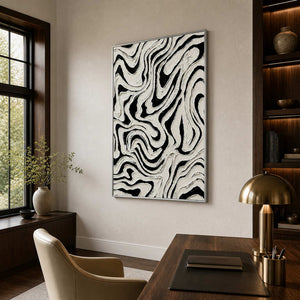 Silver framed monochrome abstract artwork with looping ridges beside an office bookshelf.