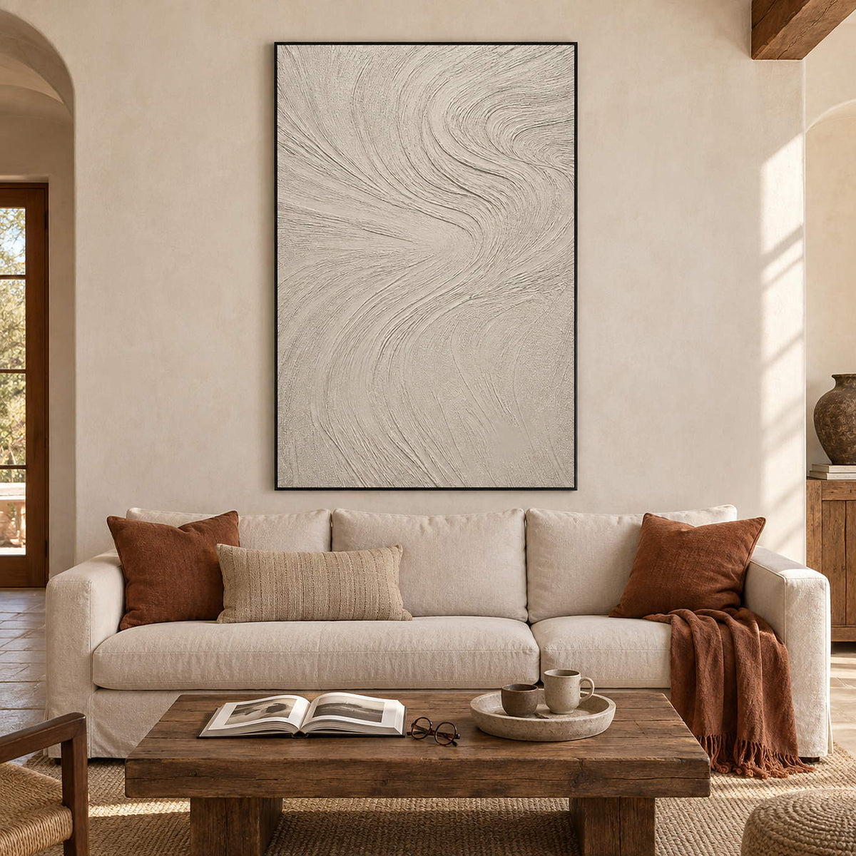 Ivory relief painting with fine flowing wave-like ridges in a black frame in a living room.