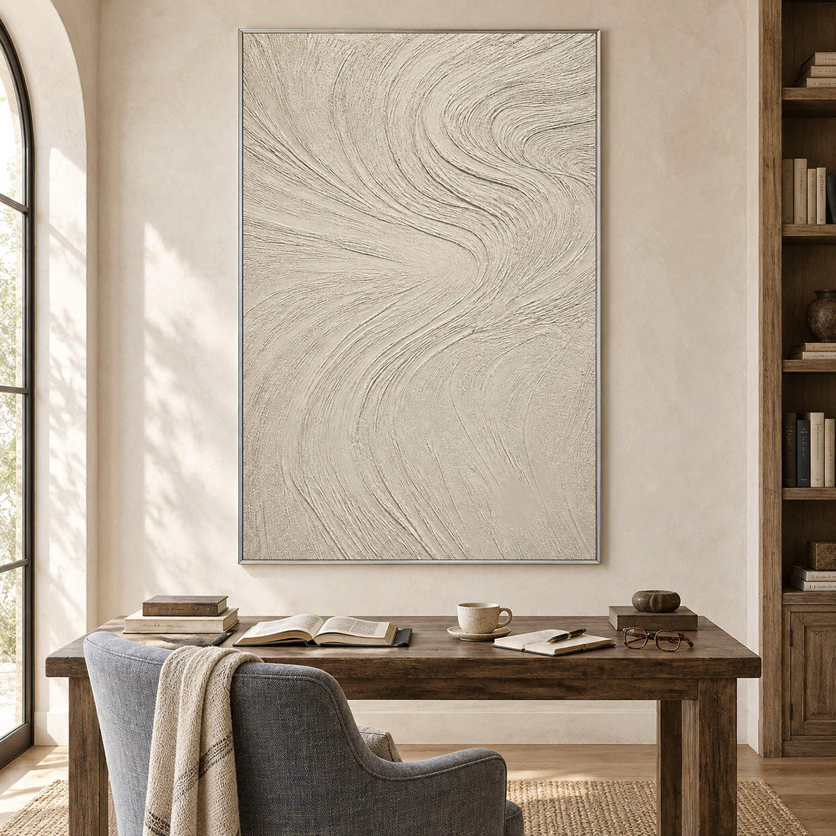 Ivory relief painting with fine flowing wave-like ridges in a silver frame in a reading room.