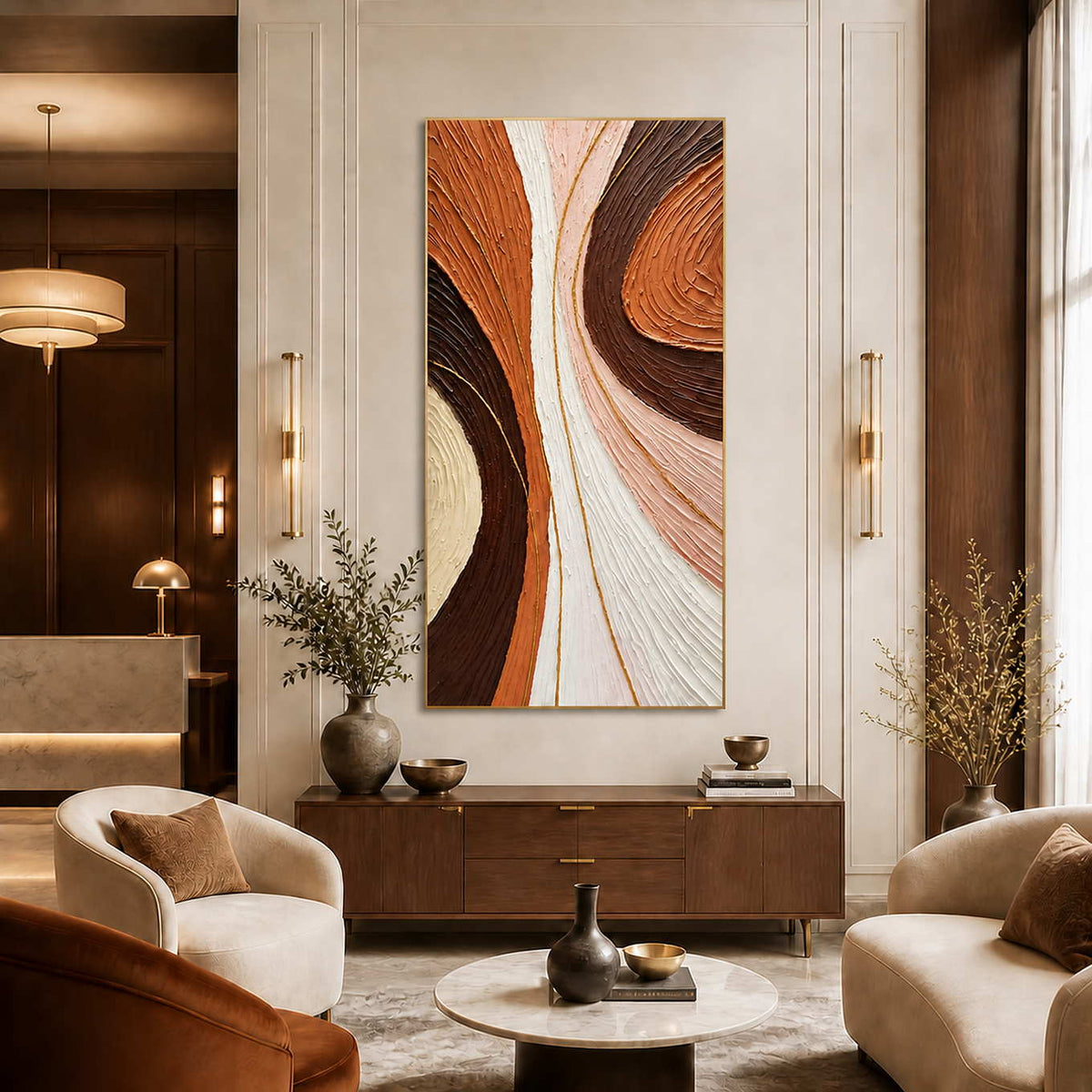 Gold-framed tall abstract wall art above a console in a warm hotel lobby.