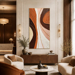 Gold-framed tall abstract wall art above a console in a warm hotel lobby.