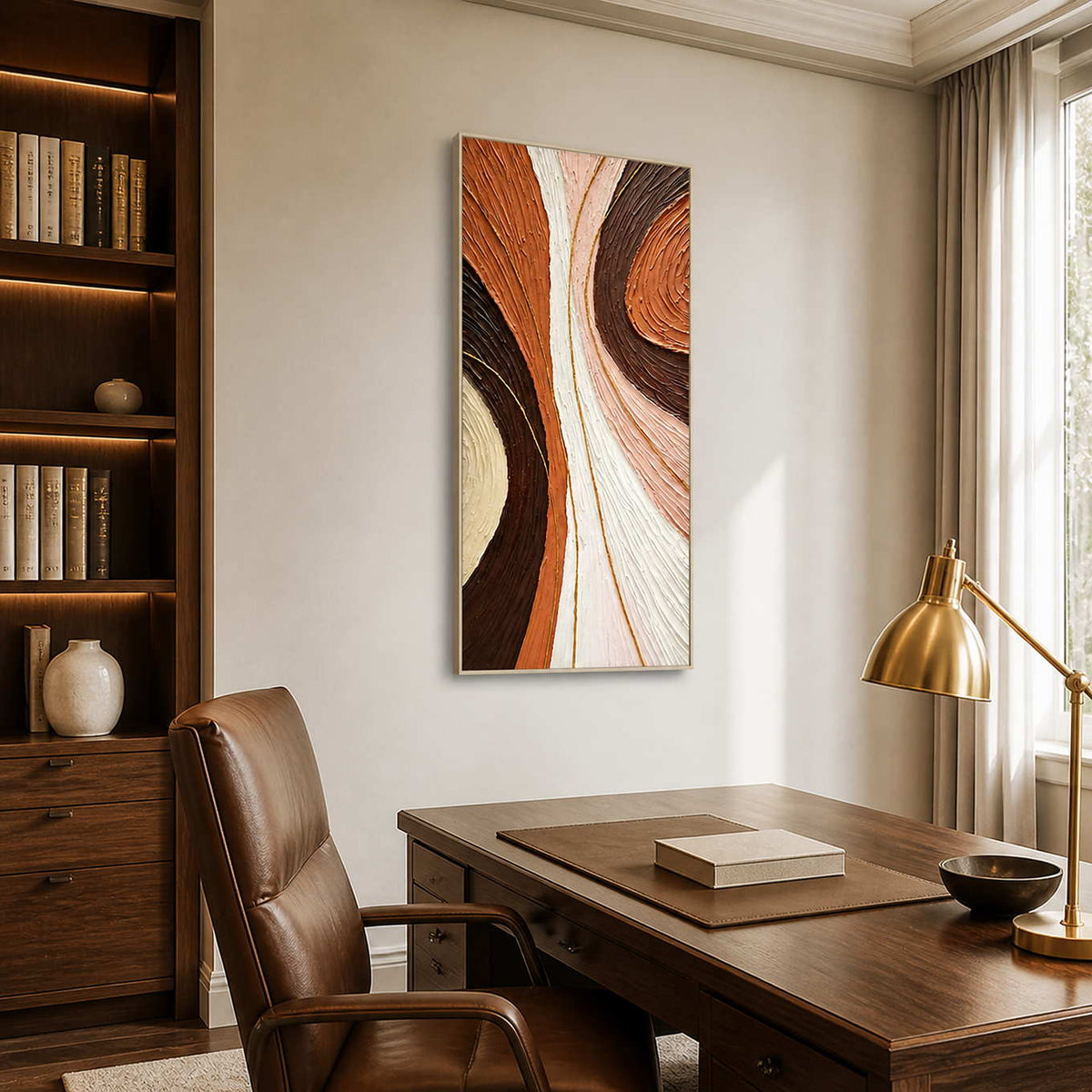 Silver-framed abstract wall art beside a bookcase and wooden desk in a study.