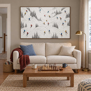 Winter at Play in a brown wood frame above a cream sofa and a coffee table set with a chessboard.