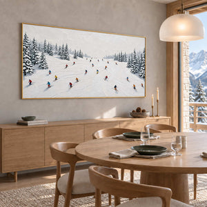 Winter Joy in a gold frame above a light wood sideboard beside a round dining table and curved wood chairs.