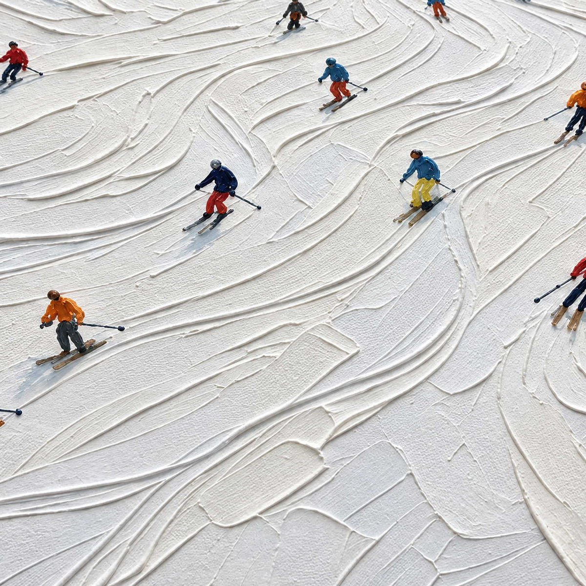 Close-up of Winter Joy showing small skiers in colorful clothing turning between curved ridges and tracks in thick white snow texture.